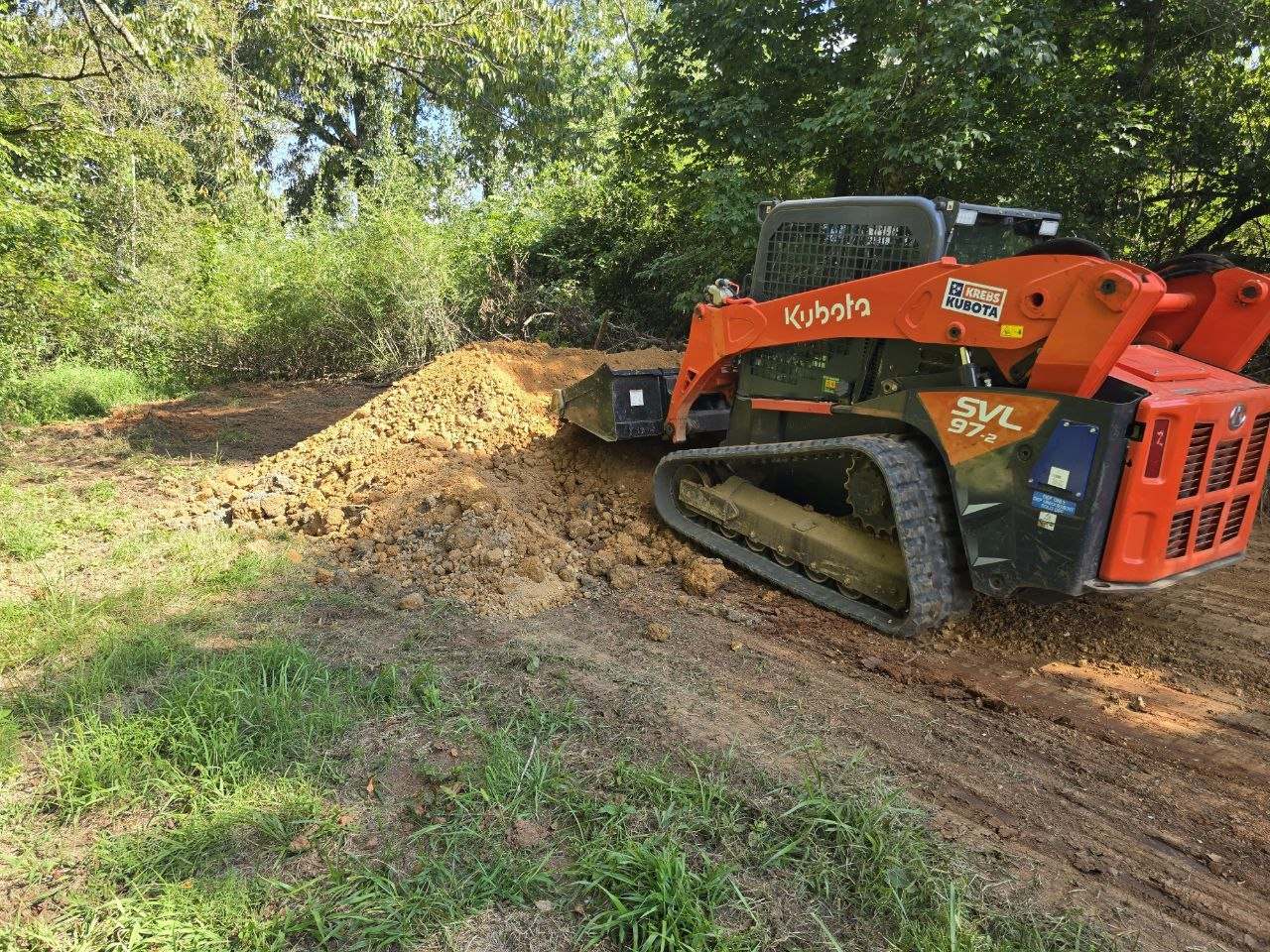 Kubota SVL 97-2 spreading material on a driveway