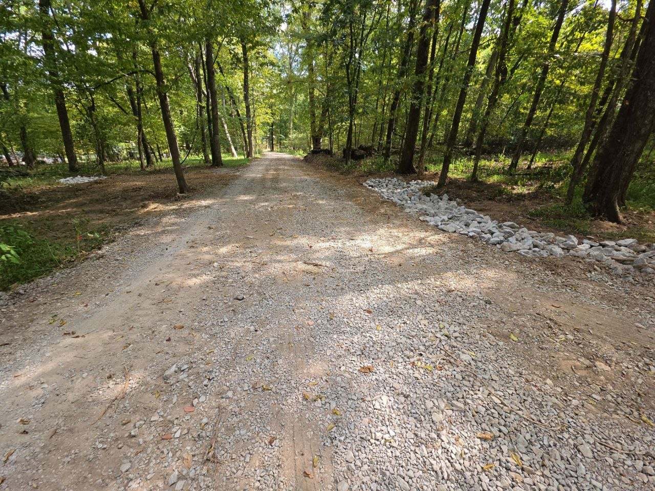 Finished gravel driveway with a stone-lined drainage edge in Pulaski, TN
