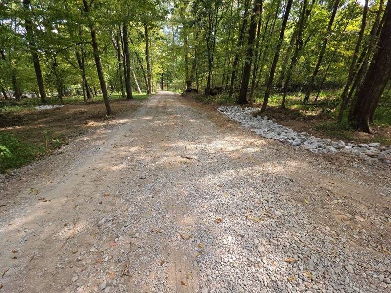 Finished gravel driveway with drainage stone beside it